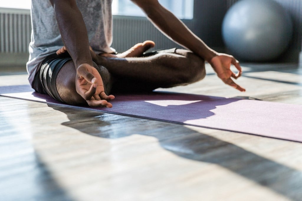 a person doing yoga on a purple mat on the floor