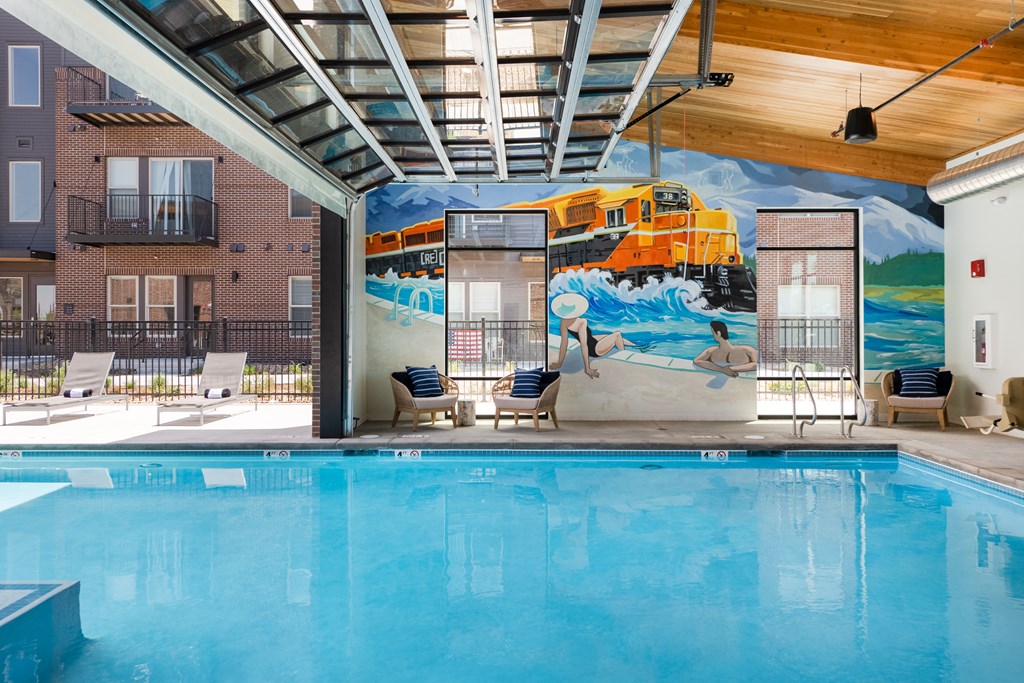 Indoor pool area with seating and mural