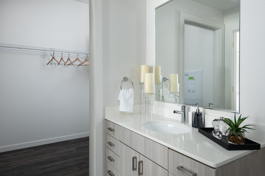 A bathroom with a white sink and a mirror.