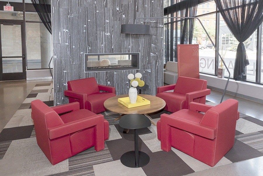 a living room with red chairs and a coffee table