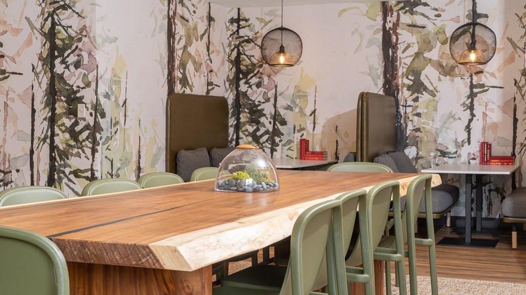 a dining room with a wooden table and green chairs
