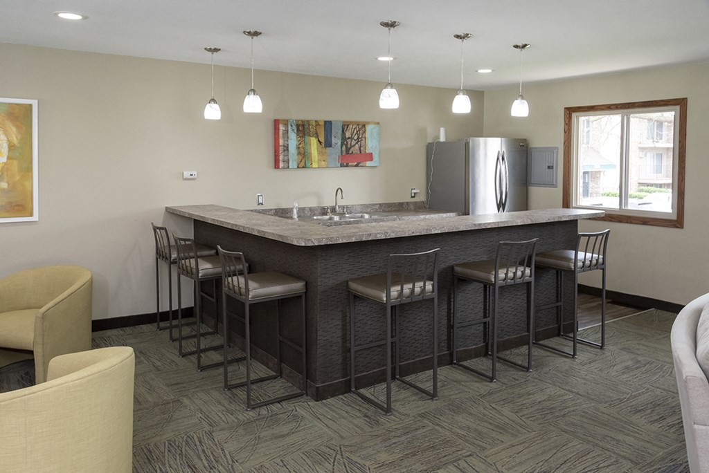 a kitchen with an island and chairs in a hotel room