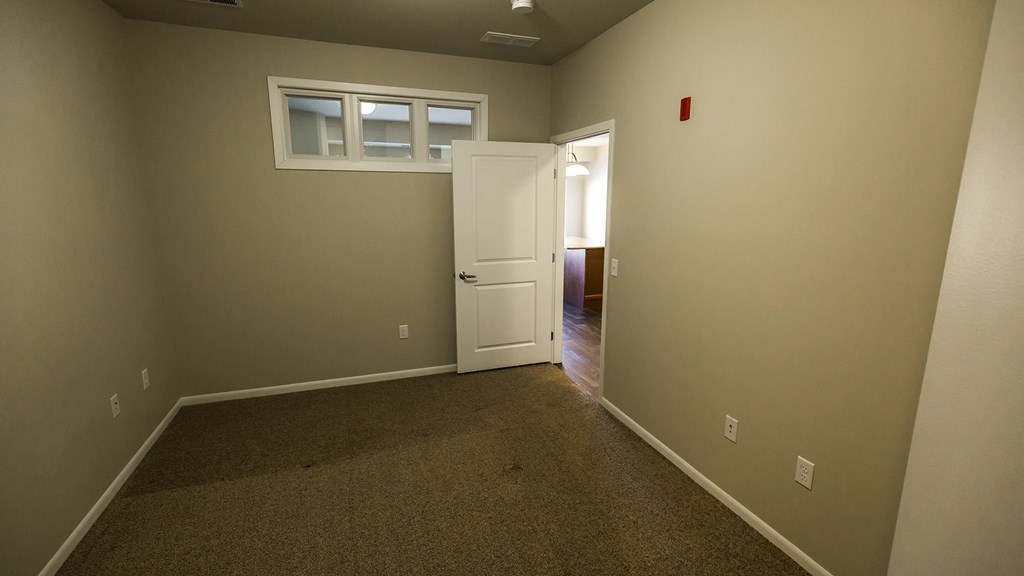 a room with a carpeted floor and a white door