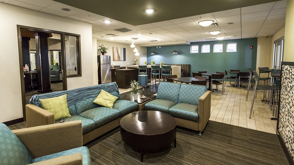 a lobby with blue couches and chairs and a table with chairs