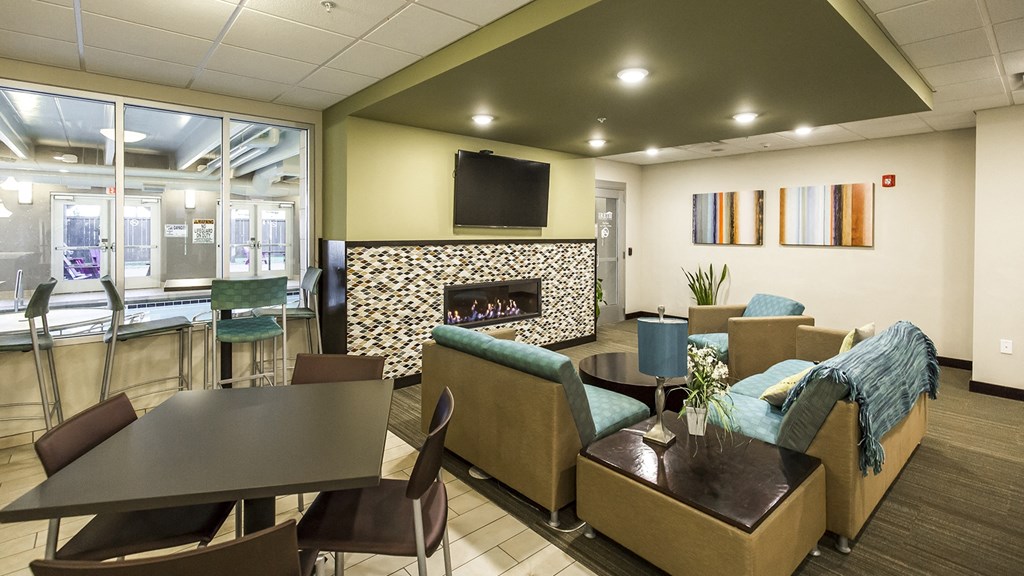 a lobby with couches chairs and tables and a fireplace