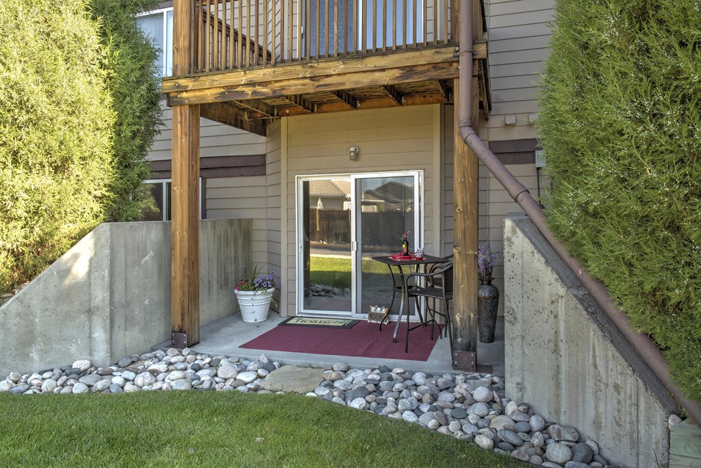 Private Patio with Rock Beds, Sliding Glass Door, and Path to Grass