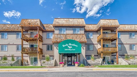 a large apartment building with a green sign in front of it