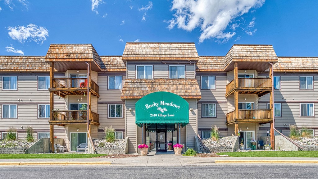 a large apartment building with a green sign in front of it
