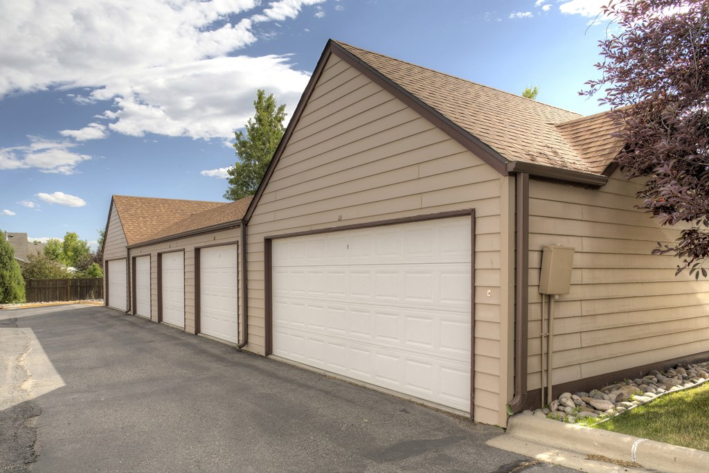 the side of a garage with a row of white garage doors