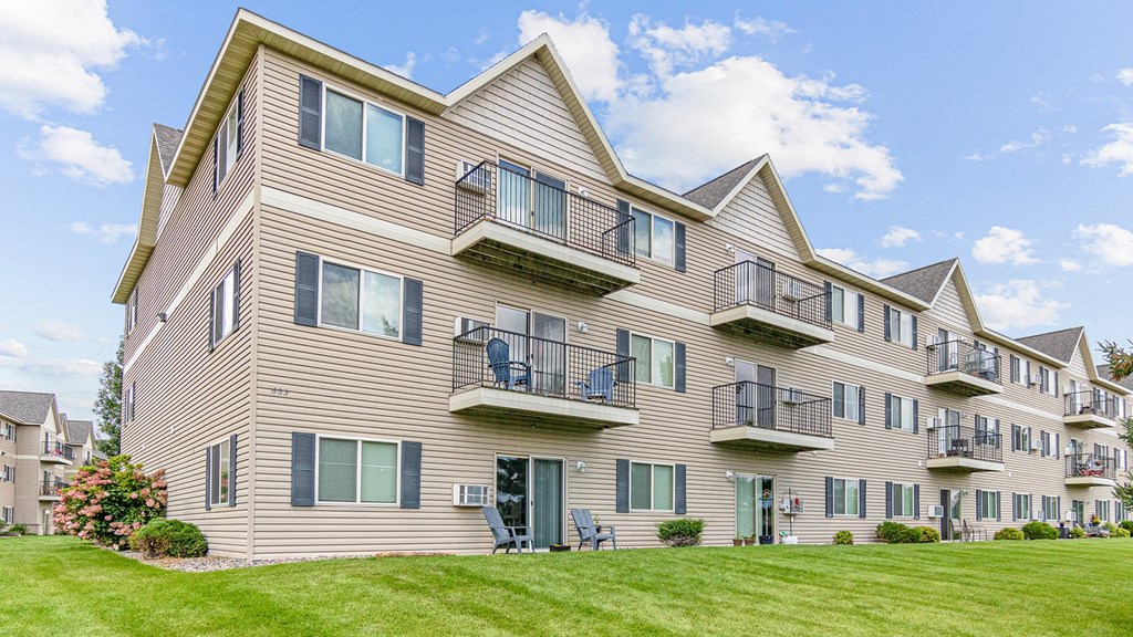 the view of an apartment building with balconies and a lawn