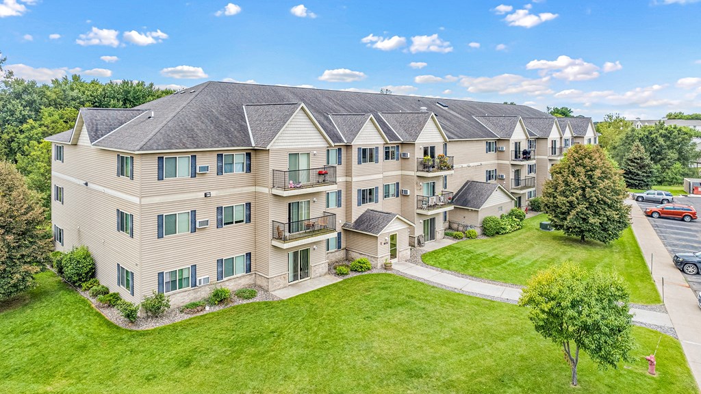 an aerial view of an apartment building with green grass and trees