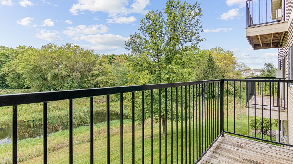 a balcony with a view of a yard and trees