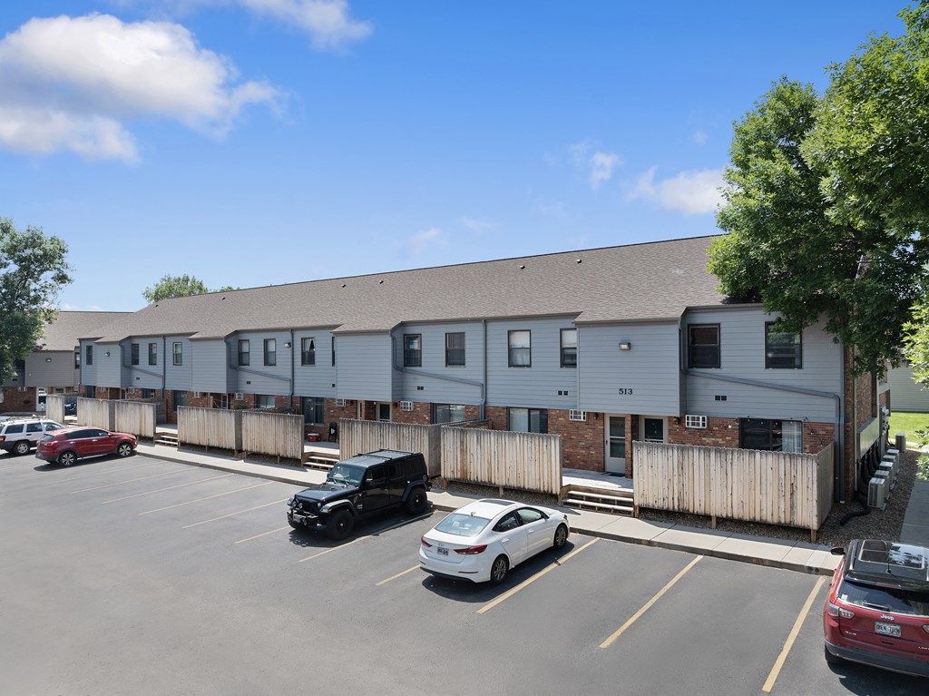 A parking lot with cars and a building in the background.