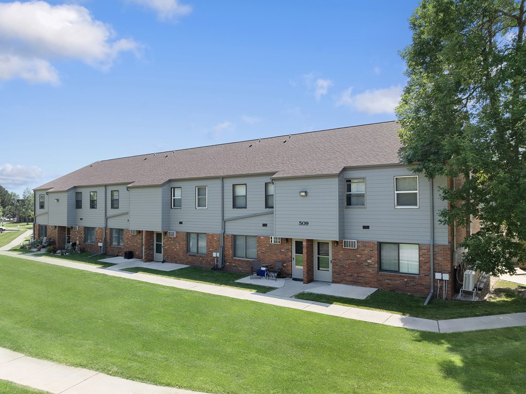 Apartment building with a green lawn in front.