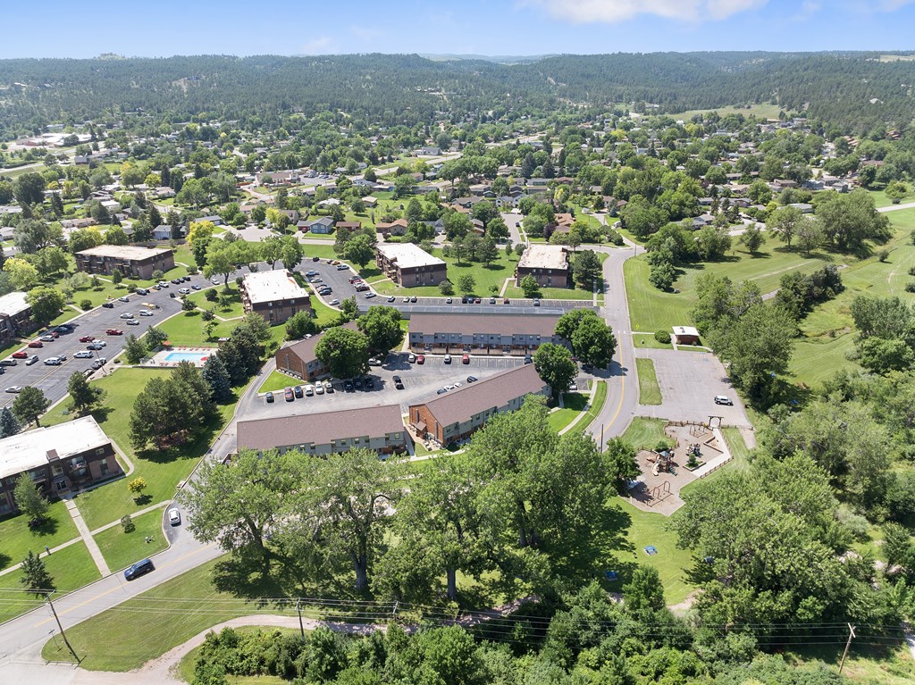 A large building complex with a parking lot in front of it.