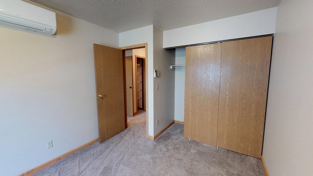 Unfurnished Bedroom with Carpet, Wood Panel Door Closet
