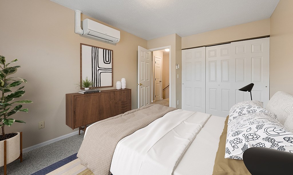 A bedroom with a large bed and a wooden dresser.