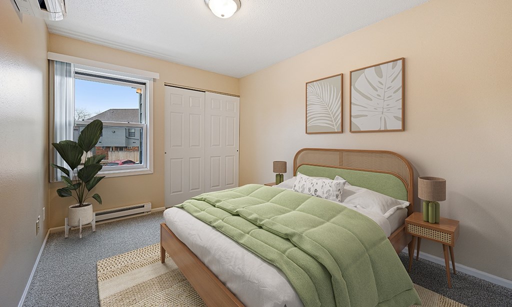 A bedroom with a bed, nightstand, and window.