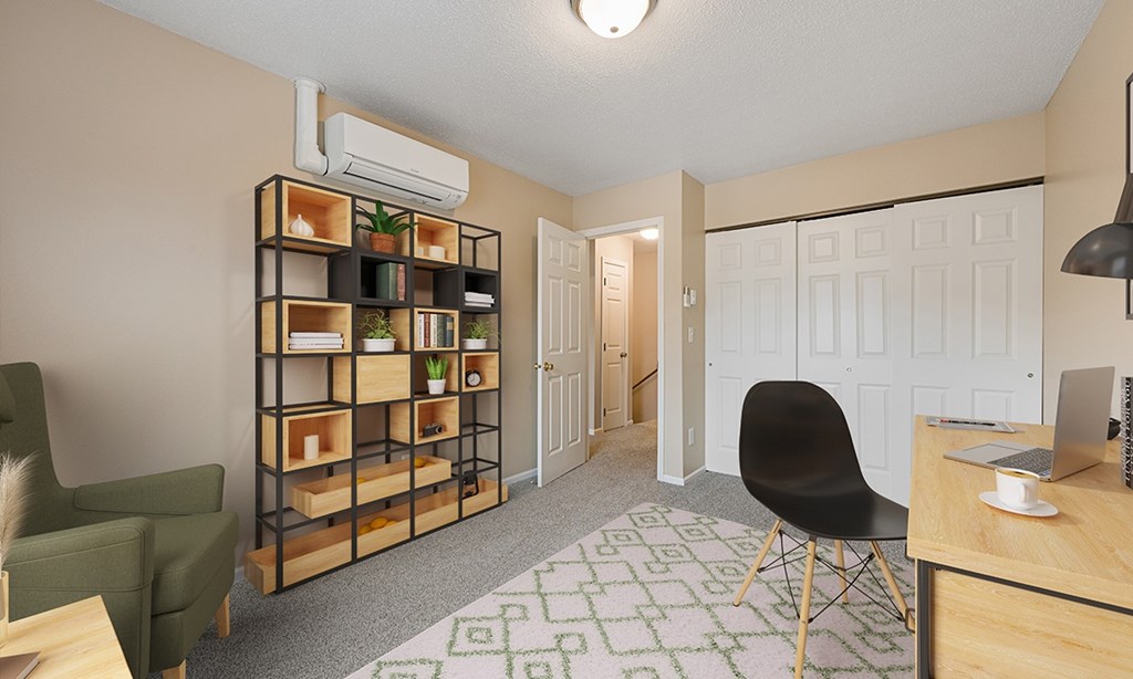 A room with a green chair, a wooden shelf, and a desk with a laptop on it.