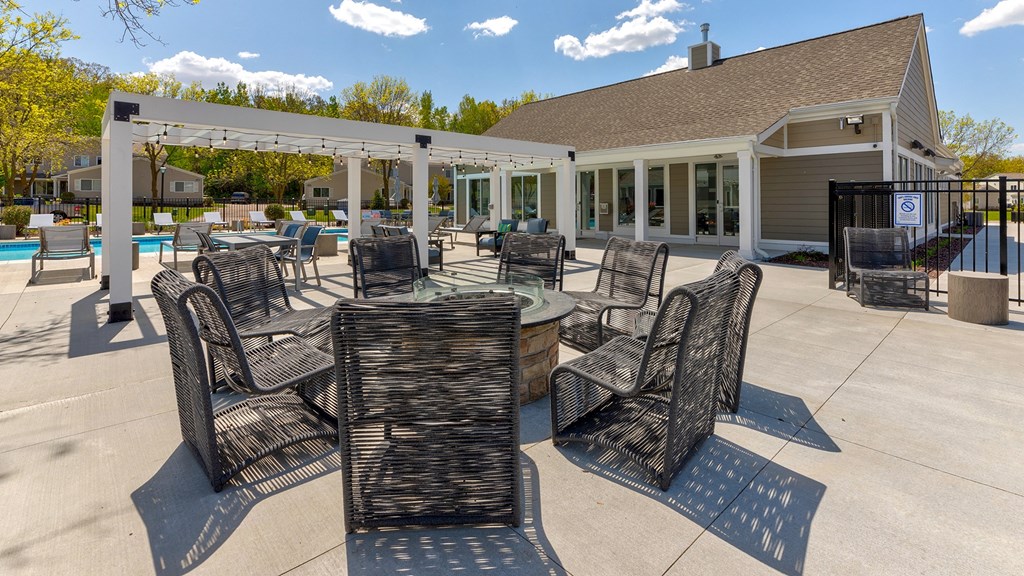 a patio with tables and chairs and a building in the background