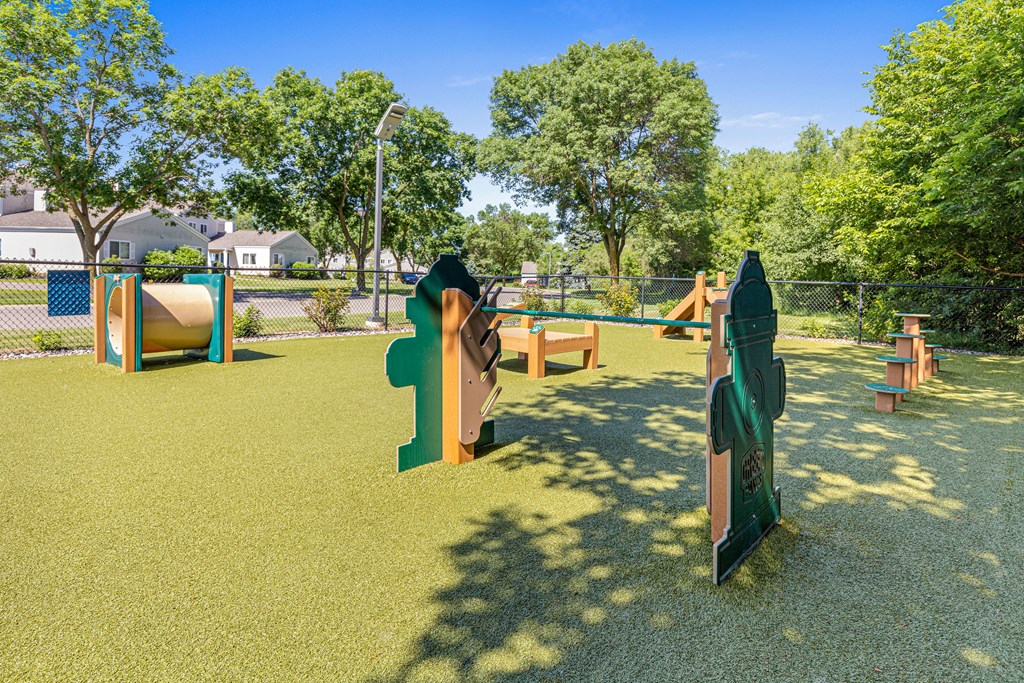 A playground with a green slide and a brown climbing frame.