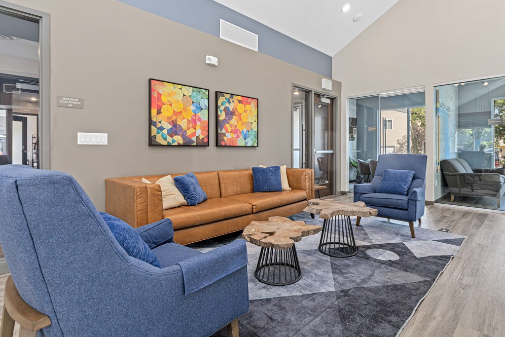 A living room with blue chairs and a brown couch.