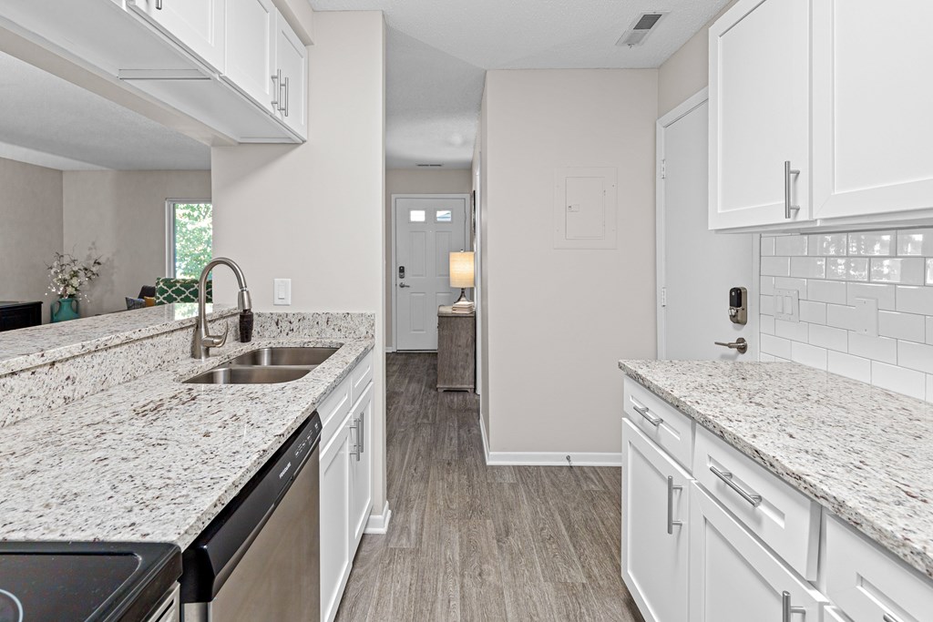 A kitchen with white cabinets and granite countertops.