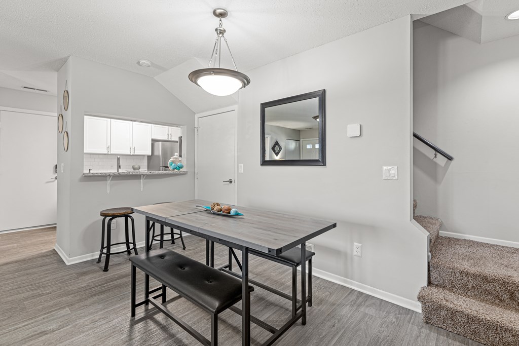 A dining room with a table and chairs.