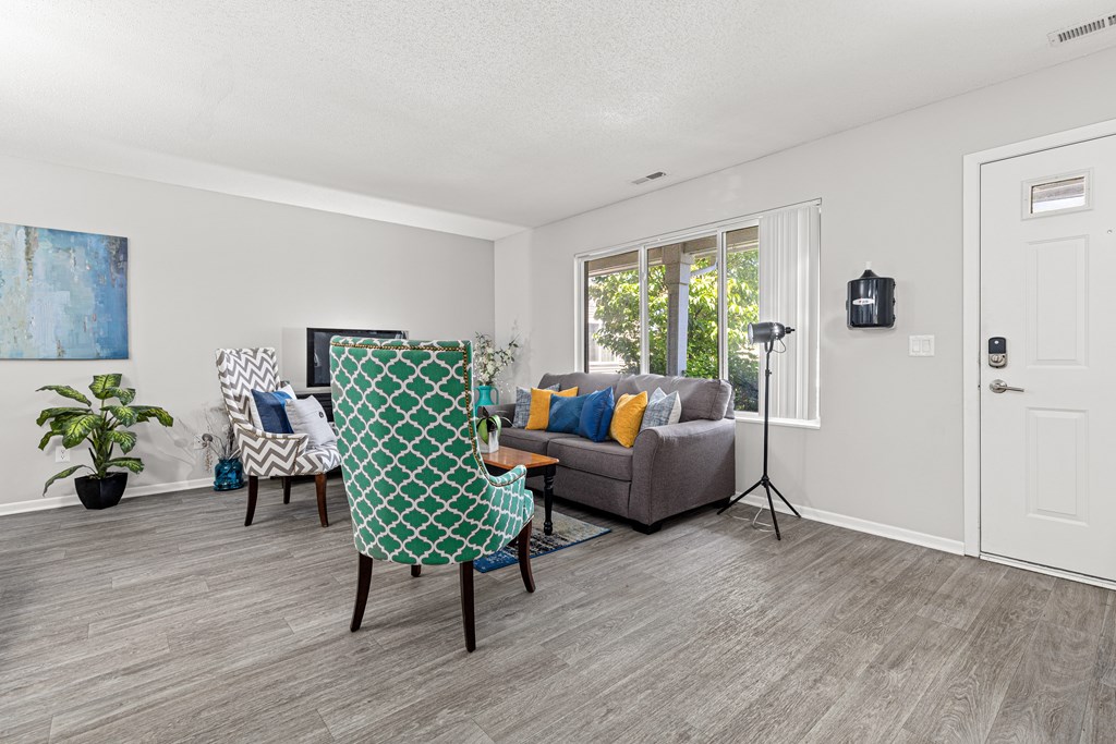 A living room with a grey couch and a green and white chair.
