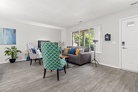 A living room with a grey couch and a green and white chair.