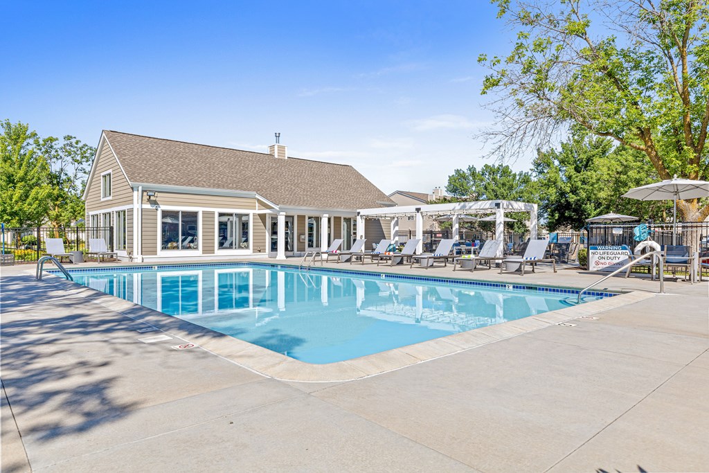 A large swimming pool with a building in the background.