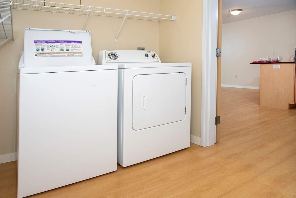 In unit washer and dryer side by side with shelf storage above.