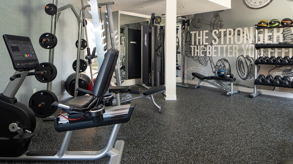 a gym with various machines and weights on the floor