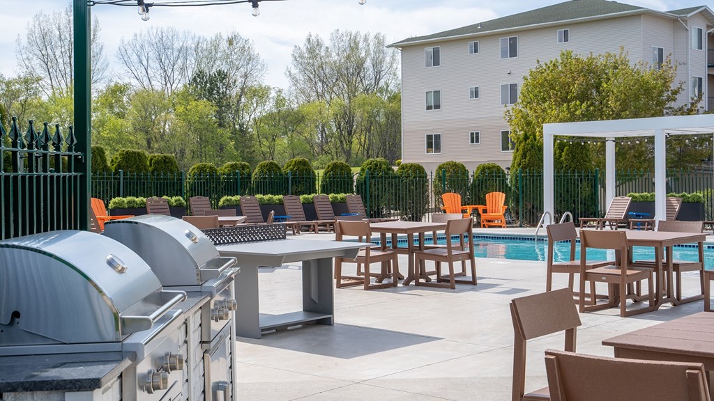an outdoor patio with tables and chairs and a swimming pool