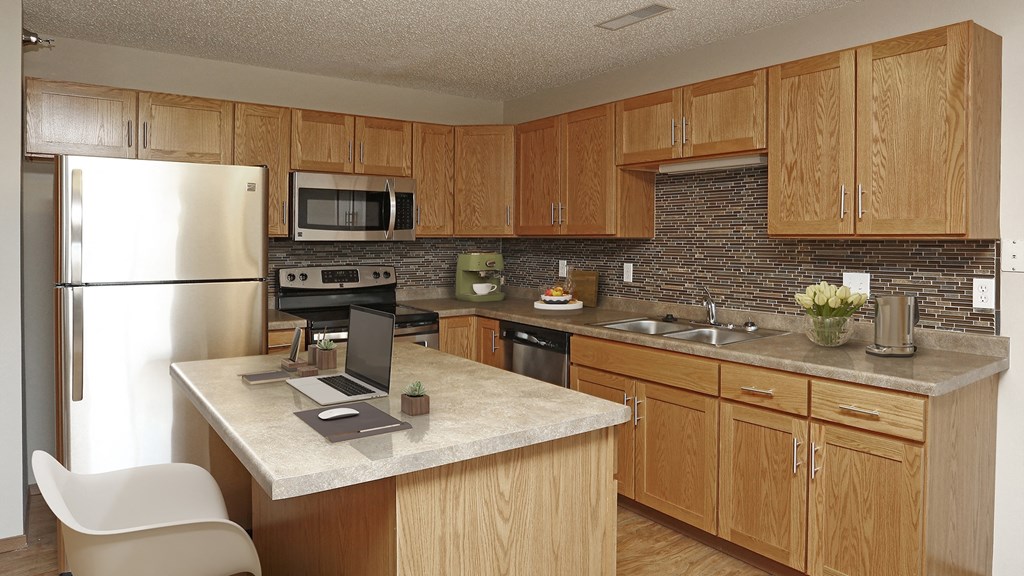 a kitchen with wooden cabinets and a marble counter top