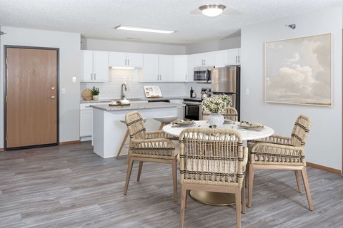 a dining room and kitchen with a table and chairs