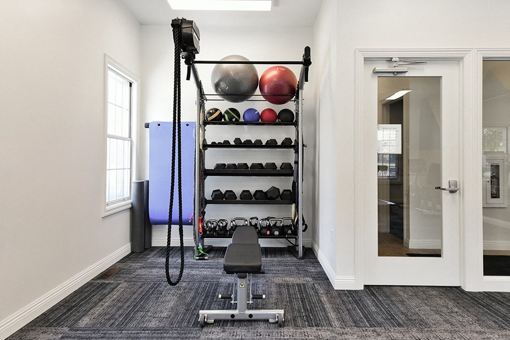A home gym with a weight rack, bench, and exercise balls. at The Donovan Apartment Homes, Lincoln 68516