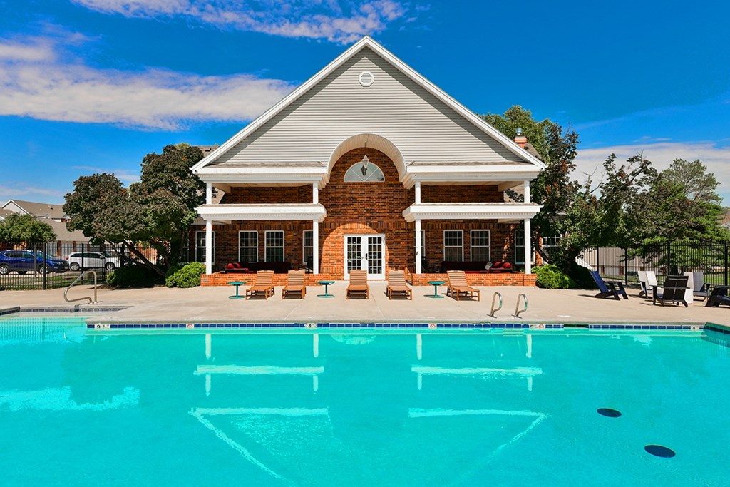 a swimming pool in front of a house with a pool