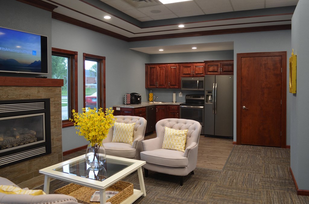 A comfortable community room with a fireplace and kitchen for relaxing or entertaining.