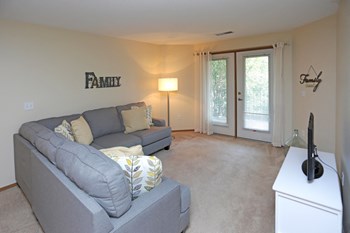 Comfortable and spacious living room with natural light from the doors leading out to your patio or balcony. - Photo Gallery 3