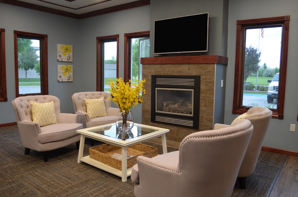 Comfortable seating, TV, and fireplace all in front of 3 gorgeous windows in the community room.