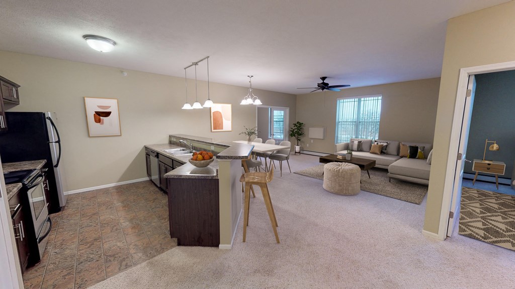 Full Kitchen with Breakfast Bar and Open Furnished Living Room with Windows