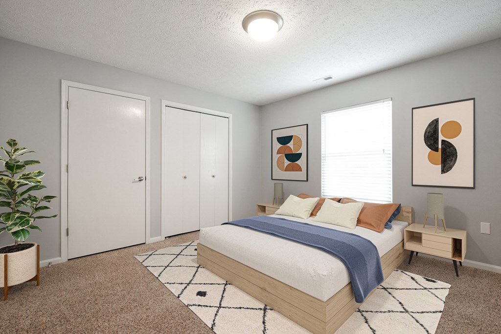 Bedroom with bay door closet, window, and bed