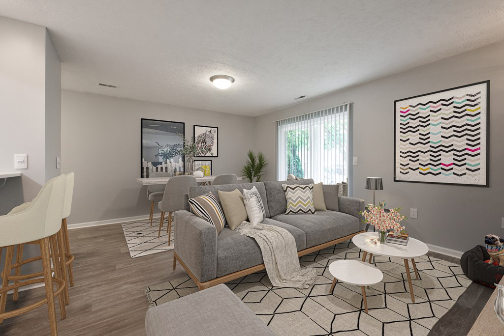 Furnished living room with couch, coffee table and barstools next to breakfast bar
