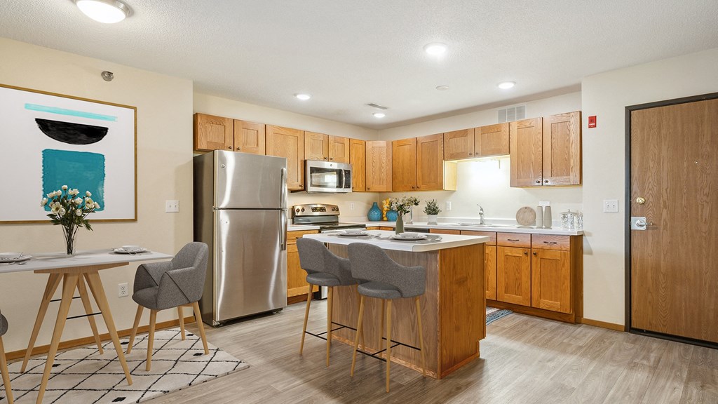 A modern kitchen with wooden cabinets and a large island.