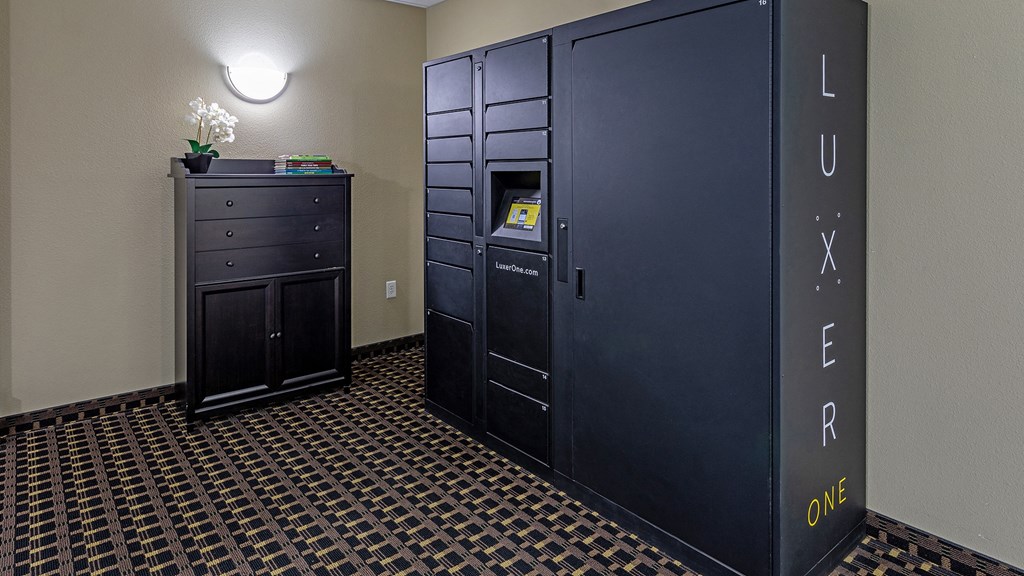 a room with two lockers and a dresser with a vase of flowers on top