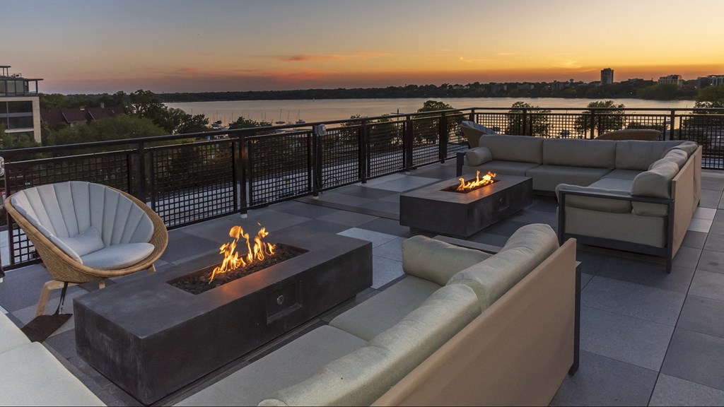 a fire pit on a patio with a view of the water