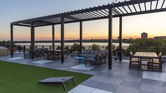 an outdoor patio with a view of the water at sunset