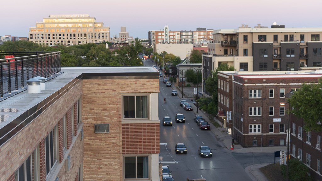 a city street with cars and buildings in the background