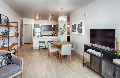 a living room and kitchen with a table and a tv